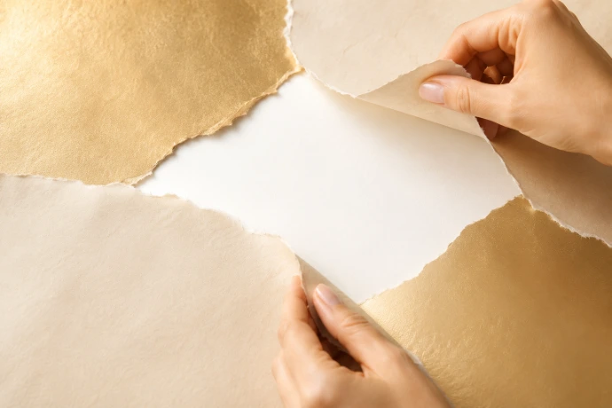 Manos retirando capas de papel, representando la eliminación de patrones y creencias limitantes con el método BR4C4.